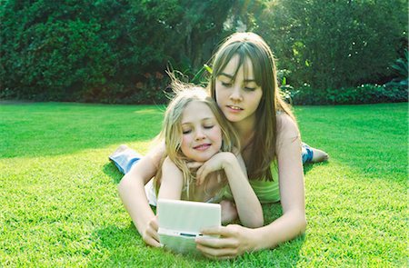 people in johannesburg - Two girls playing with Gameboy Foto de stock - Sin royalties Premium, Código: 649-03296159