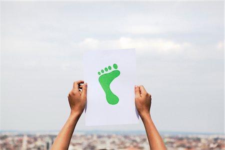 Woman holding paper green foot Stock Photo - Premium Royalty-Free, Code: 649-03296240