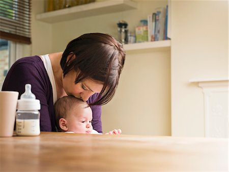 simsearch:400-05119279,k - Mother kissing her baby in the kitchen Stock Photo - Premium Royalty-Free, Code: 649-03297397