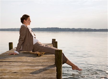 woman sitting on pier at lake Stock Photo - Premium Royalty-Free, Code: 649-03292728