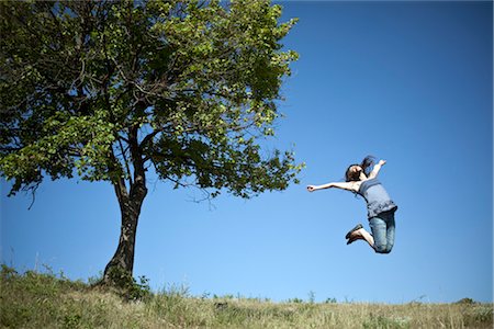 simsearch:649-03009497,k - Woman jumping by tree Stock Photo - Premium Royalty-Free, Code: 649-03362835