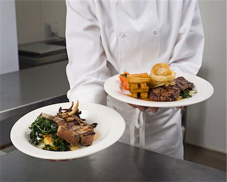 plated food - A chef holding two plated dinners Stock Photo - Premium Royalty-Free, Code: 649-03418395