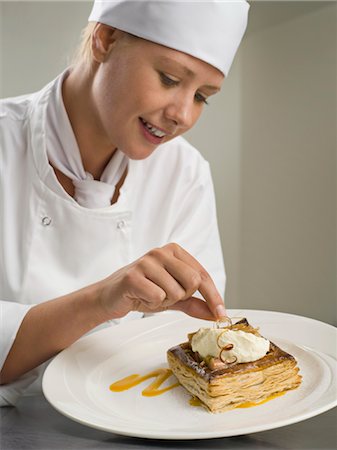 A female chef finishing a desert Stock Photo - Premium Royalty-Free, Code: 649-03418391