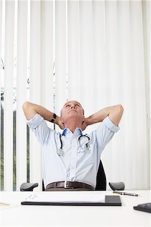 doctor office desk - Doctor leaning back on a chair Stock Photo - Premium Royalty-Free, Code: 649-03448367