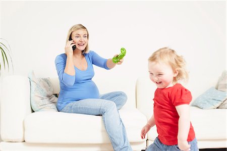 Pregnant woman on phone with toddler Stock Photo - Premium Royalty-Free, Code: 649-03448386