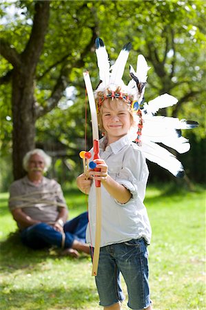 Disguised boy with toy bow and arrows Stock Photo - Premium Royalty-Free, Code: 649-03448392