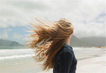 Young womans hair blowing in wind Stock Photo - Premium Royalty-Free, Code: 649-03465696