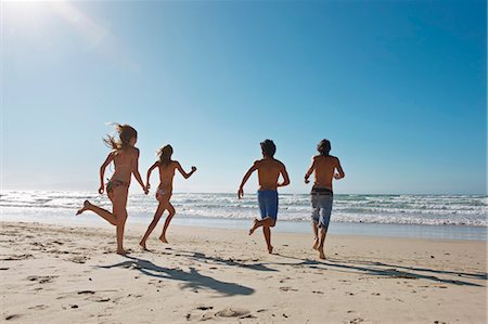 summer beach activities - Young people running towards sea Stock Photo - Premium Royalty-Free, Code: 649-03465838