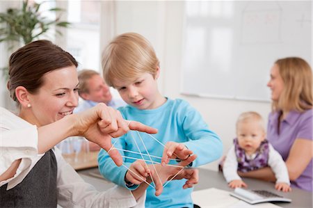 Businesswoman, boy playing string game Foto de stock - Sin royalties Premium, Código: 649-03465881