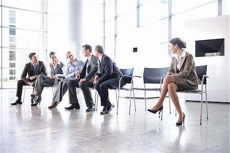 Woman sitting alone separate from group Stock Photo - Premium Royalty-Free, Code: 649-03486881