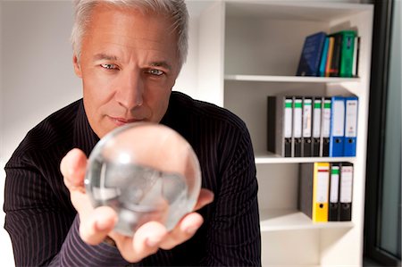 Homme tenant une boule de cristal Photographie de stock - Premium Libres de Droits, Code: 649-03487459