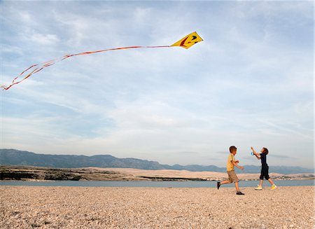 flying kite kids running - Children flying kite at beach Stock Photo - Premium Royalty-Free, Code: 649-03511053
