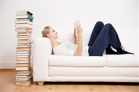 pile of books - Woman reading a book on sofa Stock Photo - Premium Royalty-Free, Code: 649-03566105