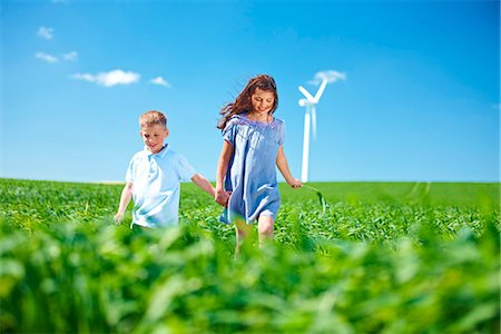 energy concept - Wind turbine, boy and girl on field Stock Photo - Premium Royalty-Free, Code: 649-03621511