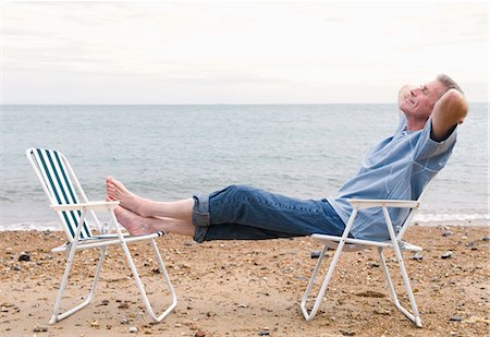 person sitting on a lawn chair - Senior relaxes on beach Stock Photo - Premium Royalty-Free, Code: 649-03622610