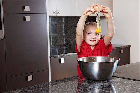 Girl cracking egg over bowl Stock Photo - Premium Royalty-Free, Code: 649-03768887