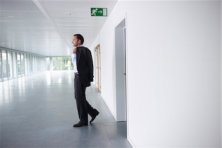 profile of man walking - Businessman walking into an empty office Stock Photo - Premium Royalty-Free, Code: 649-03769487