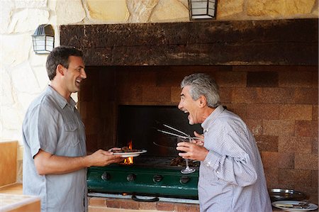 pictures of a family relaxing on the patio in summer - Two men laughing together by barbeque Stock Photo - Premium Royalty-Free, Code: 649-03769575