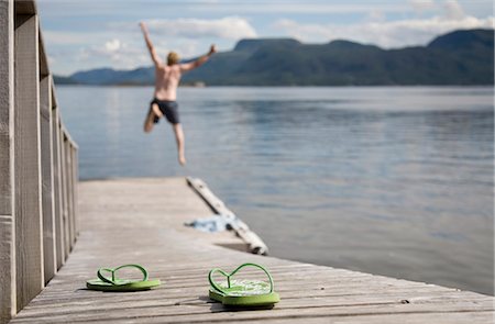 simsearch:649-03009497,k - Man jumping off wooden jetty into sea Stock Photo - Premium Royalty-Free, Code: 649-03769663