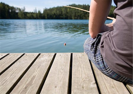 Man on jetty, fishing with bamboo rod Stock Photo - Premium Royalty-Free, Code: 649-03769673