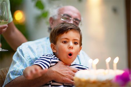 Child blowing out candles on a cake Stock Photo - Premium Royalty-Free, Code: 649-03772447