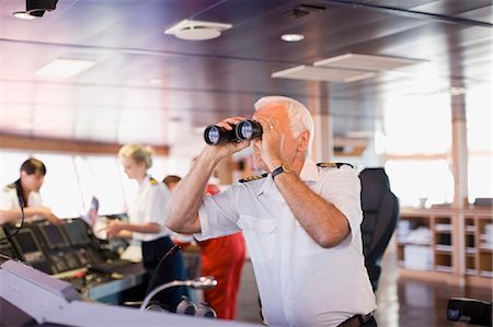 Captain on ship looking through a telescope Stock Photo - Premium Royalty-Free, Code: 649-03796316