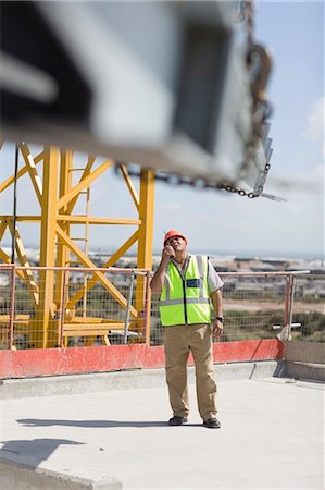 Ouvrier en bâtiment à l'aide d'un talkie-walkie Photographie de stock - Premium Libres de Droits, Code: 649-03796486