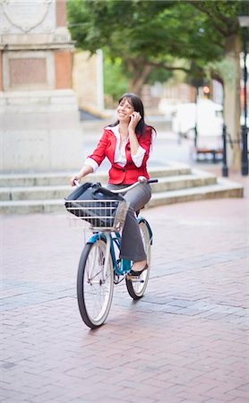 Woman on a bicycle making a phone call Stock Photo - Premium Royalty-Free, Code: 649-03796527