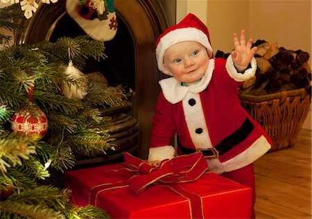 picture baby christmas - A baby santa standing next to a present Stock Photo - Premium Royalty-Free, Code: 649-03796837