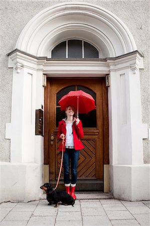 Woman with umbrella and sausage dog Stock Photo - Premium Royalty-Free, Code: 649-03797128