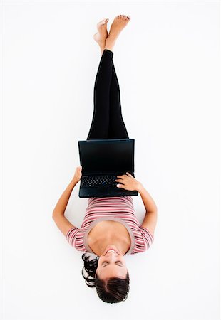 simsearch:625-00801205,k - Prone happy woman with laptop Stock Photo - Premium Royalty-Free, Code: 649-03797600