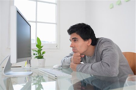 Man looking at computer Stock Photo - Premium Royalty-Free, Code: 649-03817650