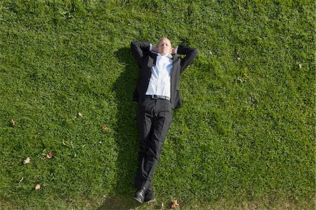 Businessman laying in grass Stock Photo - Premium Royalty-Free, Code: 649-03857387