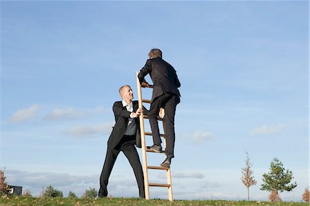 simsearch:6113-06499152,k - Businessman holding ladder for colleague Stock Photo - Premium Royalty-Free, Code: 649-03857393