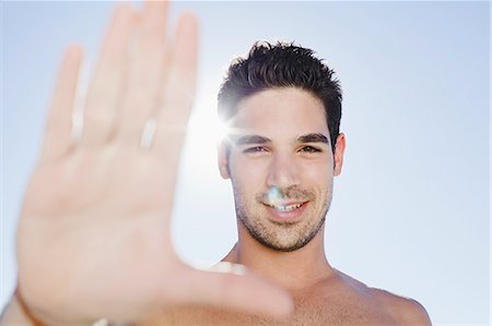 simsearch:649-06433219,k - Smiling man holding up hand Stock Photo - Premium Royalty-Free, Code: 649-03857480