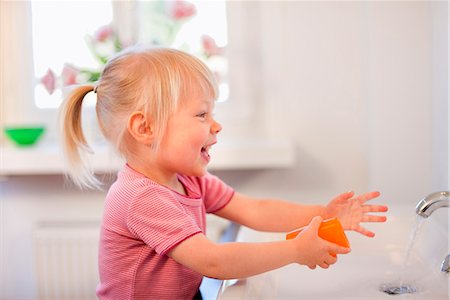 Toddler girl washing her hands Stock Photo - Premium Royalty-Free, Code: 649-03857840