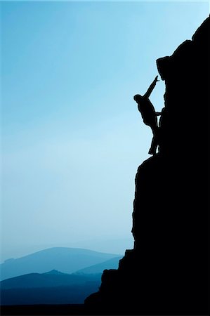 silhouette person outdoors mountains - Man climbing up rocky hillside Stock Photo - Premium Royalty-Free, Code: 649-03858398