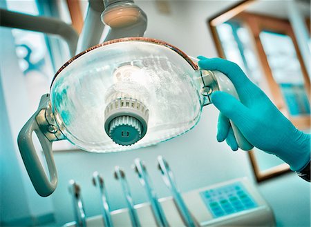 Dentist adjusting lamp in office Stock Photo - Premium Royalty-Free, Code: 649-03858787