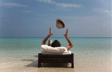 simsearch:628-00919176,k - Man relaxing on daybed at tropical beach Stock Photo - Premium Royalty-Free, Code: 649-03881354