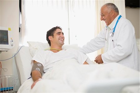 ethnic mature patient laughing - Doctor tending to hospital patient Stock Photo - Premium Royalty-Free, Code: 649-03881640