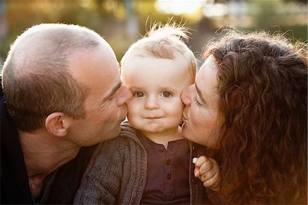 simsearch:649-03770663,k - Parents kissing baby's cheeks outdoors Stock Photo - Premium Royalty-Free, Code: 649-03881881