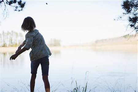 Girl skipping stones in lake Stock Photo - Premium Royalty-Free, Code: 649-03882532