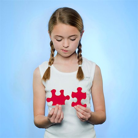 simsearch:695-03376367,k - Studio portrait of girl (10-11) holding red jigsaw puzzles Stock Photo - Premium Royalty-Free, Code: 640-05761254