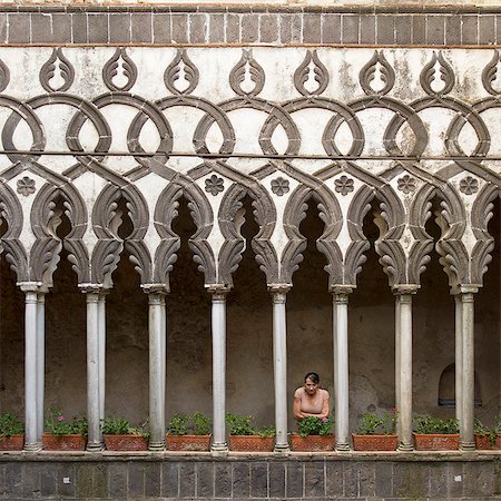 Italy, Ravello, Woman standing on balcony between ornate columns Stock Photo - Premium Royalty-Free, Code: 640-06050031