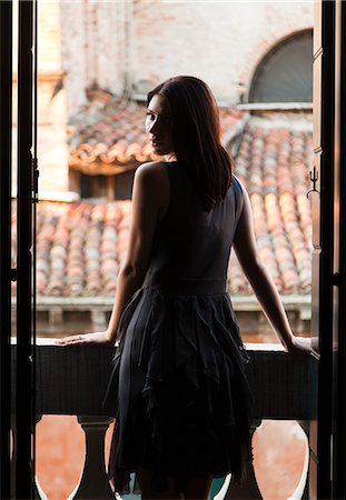 Italy, Venice, Young woman standing in balcony door Stock Photo - Premium Royalty-Free, Code: 640-06050218