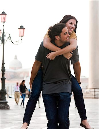 simsearch:640-06050299,k - Italy, Venice, Young man giving piggyback ride to woman on St. Mark's Square Stock Photo - Premium Royalty-Free, Code: 640-06050269