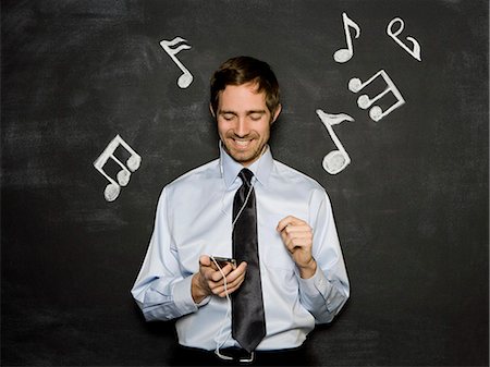 man listening to an mp3 player Stock Photo - Premium Royalty-Free, Code: 640-06050876