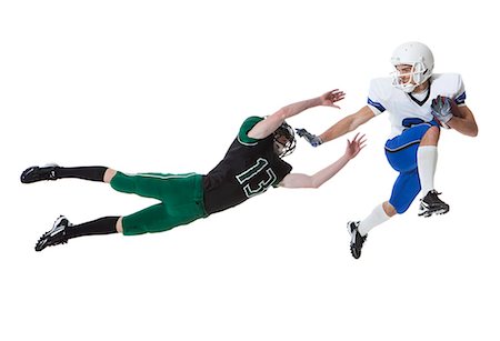 diving (not water) - Two male players of American football fighting for ball, studio shot Stock Photo - Premium Royalty-Free, Code: 640-06963147