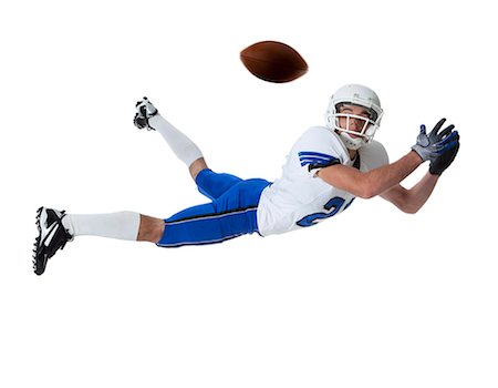 diving (not water) - Male player of American football catching ball, studio shot Stock Photo - Premium Royalty-Free, Code: 640-06963169