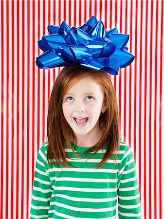 Studio shot of girl (4-5) with large gift bow on head Stock Photo - Premium Royalty-Free, Code: 640-06963707